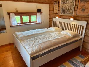 a white bed in a room with a window at Lake Lodge Rönnäs in Leksand