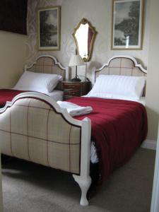 a bed room with a white bedspread and two lamps at Holly Tree B&B in Bromyard