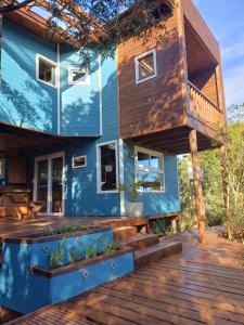 ein blaues Haus mit einer Holzterrasse in der Unterkunft Nairandey in La Pedrera