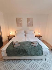 1 cama blanca grande con 2 toallas en Bright and central with 2 beds incl workspace en Bochum