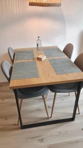 a wooden table with two chairs and a bottle on it at Bright and central with 2 beds incl workspace in Bochum