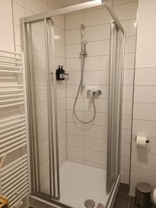 baño con ducha y puerta de cristal en Bright and central with 2 beds incl workspace, en Bochum