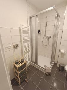 a white bathroom with a shower and a sink at Bright and central with 2 beds incl workspace in Bochum