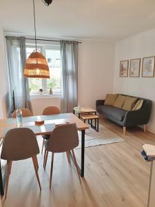 a living room with a table and chairs and a couch at Bright and central with 2 beds incl workspace in Bochum