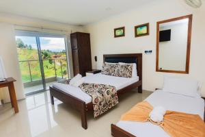 a hotel room with two beds and a balcony at Hotel Verony Guatape in Guatapé