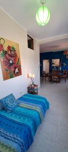 a bedroom with a blue bed with a painting on the wall at Ayres de Catamarca in San Fernando del Valle de Catamarca