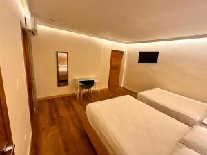um quarto de hotel com duas camas e uma mesa em Hotel La Colonia em Santo Domingo