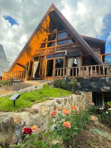 a log cabin with flowers in front of it at Ban Kaew Mo Ra Glamping & Restaurant in Pang Mapha