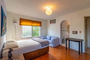 Schlafzimmer mit einem Bett, einem Tisch und einem Fenster in der Unterkunft Espacioso y Cómodo Dpto. Bien Iluminado en Mty in Monterrey