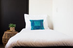 a bed with a blue pillow on top of it at Hotel Snouck van Loosen in Enkhuizen