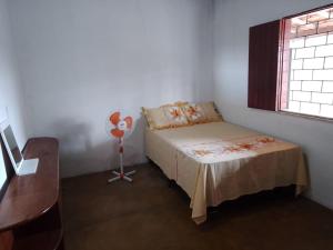 um quarto com uma cama, uma secretária e uma janela em Casa à 200 metros da praia em Porto Seguro