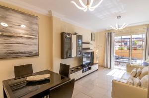 a living room with a dining table and a tv at Terrazas del Duque II Hideaway in Adeje