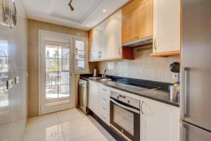 uma cozinha com armários brancos e um lavatório em Terrazas del Duque II Hideaway em Adeje
