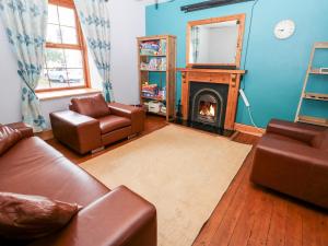 uma sala de estar com um sofá e uma lareira em Glenwood House em Kirkby Stephen
