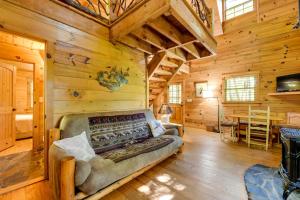 una sala de estar con sofá en una cabaña de madera en Quiet Balsam Grove Cabin Porch, Hot Tub, Dogs OK, en Balsam Grove