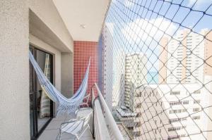 a balcony with a hammock and a view of a city at Iracema Apartament in Fortaleza
