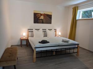 Un dormitorio con una cama con dos lámparas y una ventana. en Fewo New Oberdorf, en Fautenbach