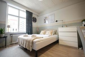 een kleine slaapkamer met een bed en een raam bij Atmospheric hundred-year-old stone house apartment near Aurajoki in Turku