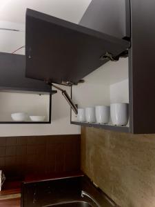 a kitchen with white cups on a shelf at Asikkalan Motelli in Vesivehmaa