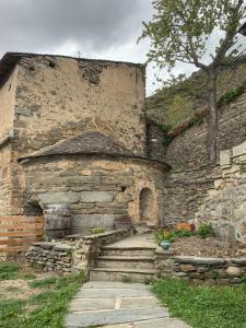 a stone building with stairs and a tree at Gîte paisible au cœur des montagnes à Nohèdes in Nohèdes