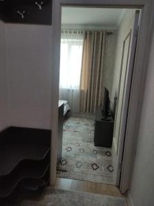 a room with a door leading to a bedroom with a window at Светлая и уютная квартира в южной части Бишкека! in Bishkek