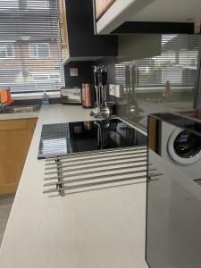 a kitchen counter with a sink and a microwave at Charlesworth House in Crewe