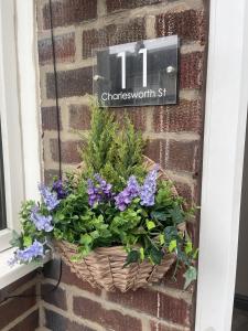 a basket of flowers on a brick wall at Charlesworth House in Crewe