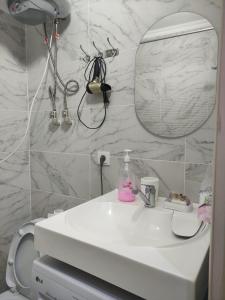 a bathroom with a white sink and a mirror at Светлая и уютная квартира в южной части Бишкека! in Bishkek