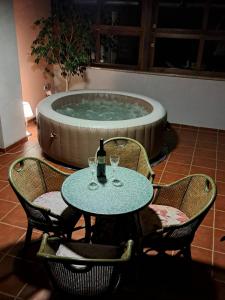 una mesa con una botella de vino delante de una bañera en Kuca sa bazenom Teja, en Arandjelovac