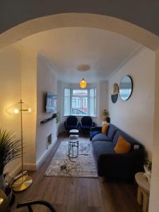 a living room with a blue couch and a table at LouLuxe Modern Cosy Home in Manchester