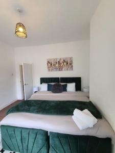 a bedroom with a large bed with a green blanket at LouLuxe Modern Cosy Home in Manchester