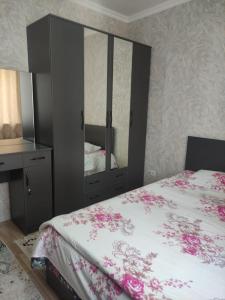 a bedroom with a bed with a dresser and a mirror at Светлая и уютная квартира в южной части Бишкека! in Bishkek