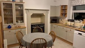 een keuken met een tafel en een tafel en stoelen bij Amelie Cottage in Beaumaris