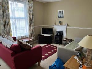 a living room with a couch and a tv at Amelie Cottage in Beaumaris