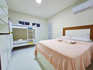 a bedroom with a bed and a bunk bed at MANERO HOSTEL e POUSADA in Natal