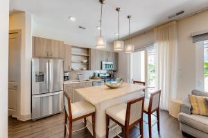 cocina con mesa y sillas y cocina con nevera en The Pointe 3-315, en Rosemary Beach