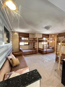 a living room with two bunk beds and a couch at ASNFU AUBERGe in Imsouane