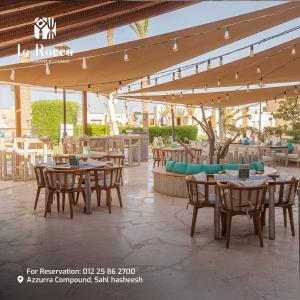 a patio with tables and chairs under a roof at Ladybird - Azzurra Beauty in Hurghada