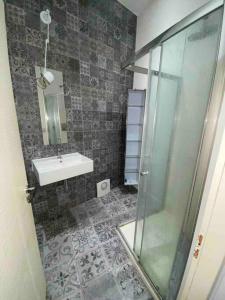 een badkamer met een wastafel en een glazen douche bij Appart le Charmant, Cœur Historique, Climatisation et Wifi in Montpellier