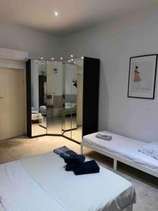 een kamer met 2 bedden en een kamer met spiegels bij Appart le Charmant, Cœur Historique, Climatisation et Wifi in Montpellier