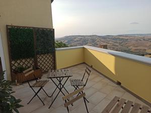 balkon z krzesłami i stołami w budynku w obiekcie A Due Passi w mieście Grassano