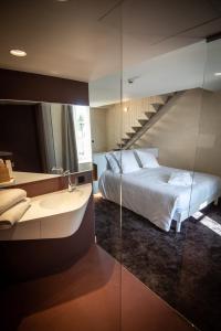 a bedroom with a bed and a bathroom with a sink at Le Roscanvec in Vannes
