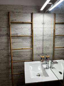 La salle de bains est pourvue d'un lavabo blanc et d'un mur en bois. dans l'établissement Studio Chaleureux au Cap d’Agde, au Cap d'Agde