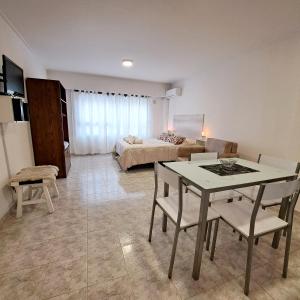 sala de estar con mesa, sillas y cama en Apartamento Caseros en Córdoba