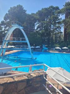 een groot zwembad met een boog in het midden bij Precioso apartamento en un entorno verde y tranquilo en playa mansa in Punta del Este