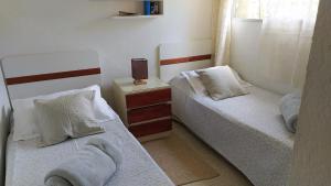 een kamer met 2 bedden en een nachtkastje met rokken bij Precioso apartamento en un entorno verde y tranquilo en playa mansa in Punta del Este