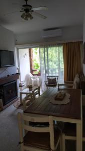 een woonkamer met een houten tafel en een open haard bij Precioso apartamento en un entorno verde y tranquilo en playa mansa in Punta del Este