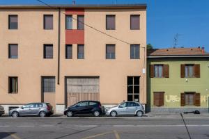 drei Autos auf einem Parkplatz vor einem Gebäude geparkt in der Unterkunft Moderno appartamento a due passi dai Navigli in Rozzano