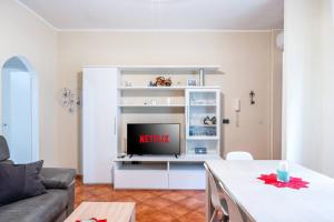a living room with a tv on a white entertainment center at Moderno appartamento a due passi dai Navigli in Rozzano