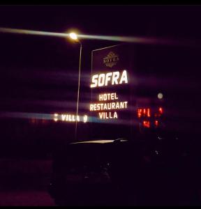 a sign for a hotel restaurant villa at night at Hotel sofra in Ferizaj